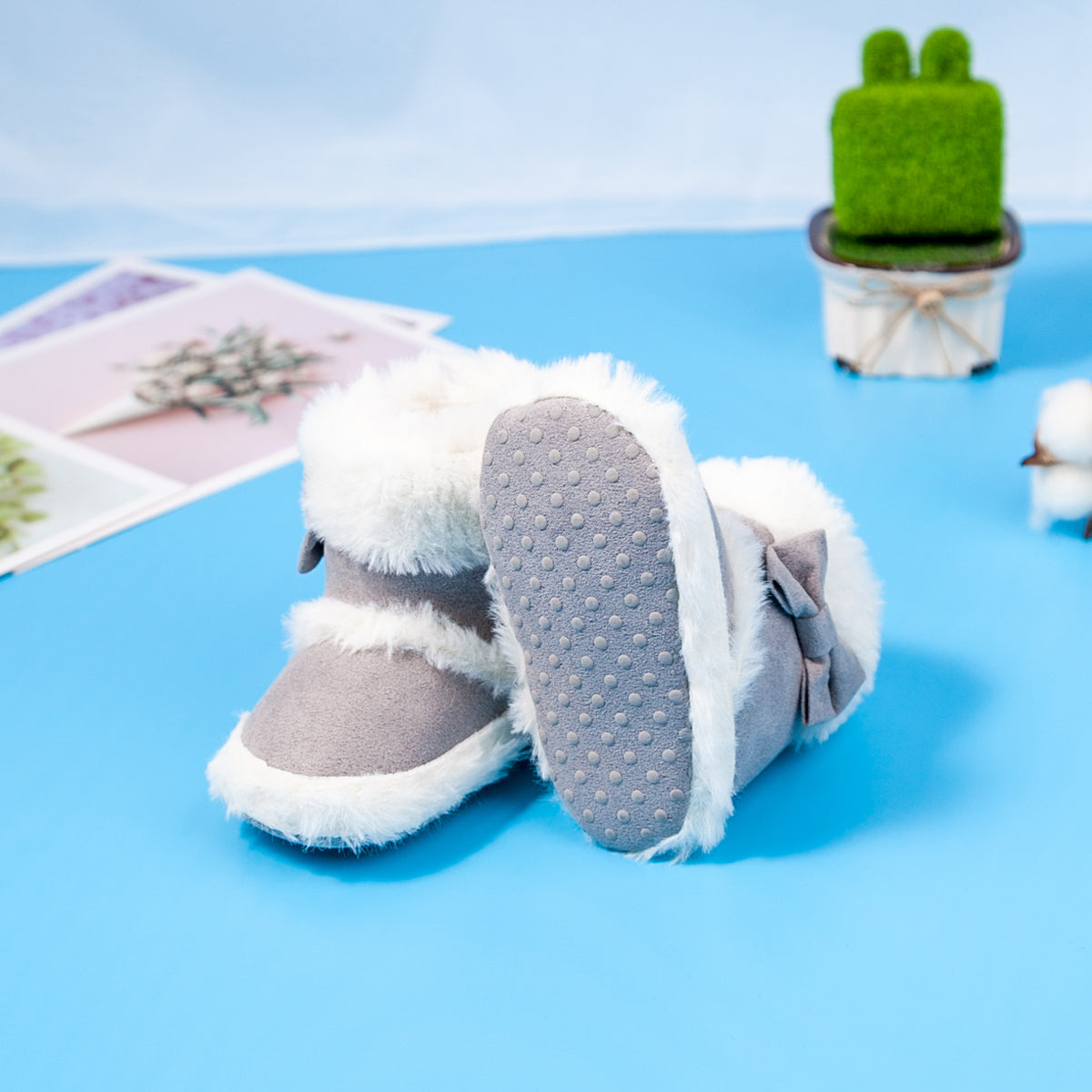 Pantufas de bebé com detalhe de laço e pele sintética